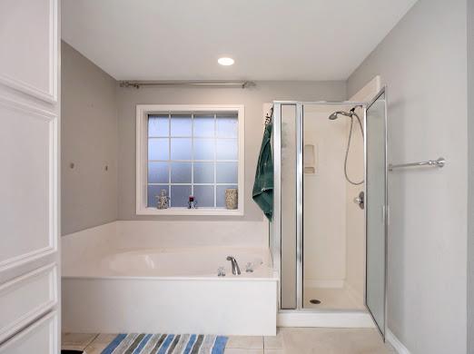 bathroom with tile patterned flooring and shower with separate bathtub