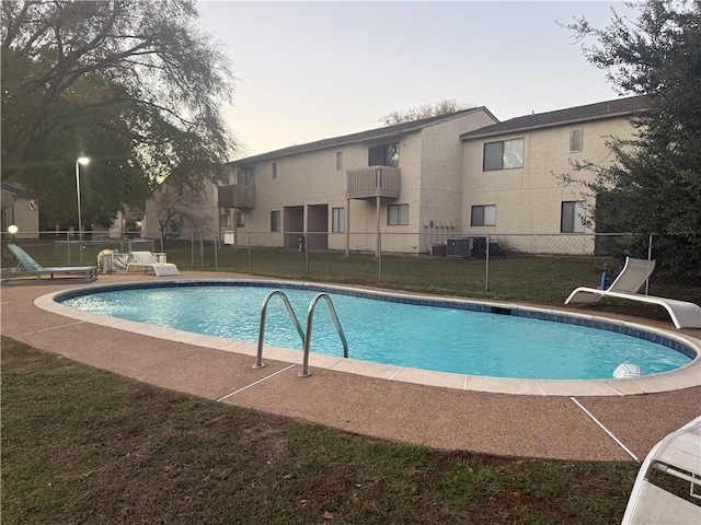 view of swimming pool with a yard and central AC