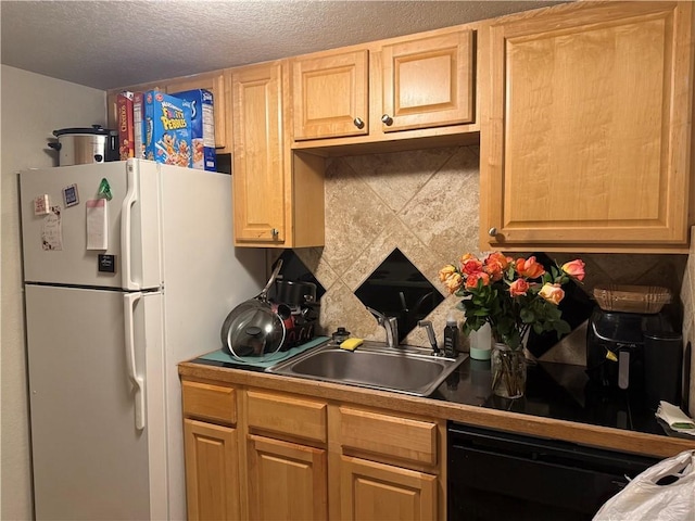 kitchen with white refrigerator, sink, decorative backsplash, black dishwasher, and a textured ceiling