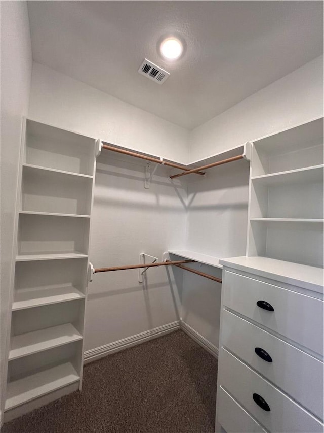 spacious closet featuring dark carpet