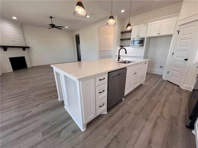 kitchen with sink, pendant lighting, a center island with sink, white cabinets, and appliances with stainless steel finishes