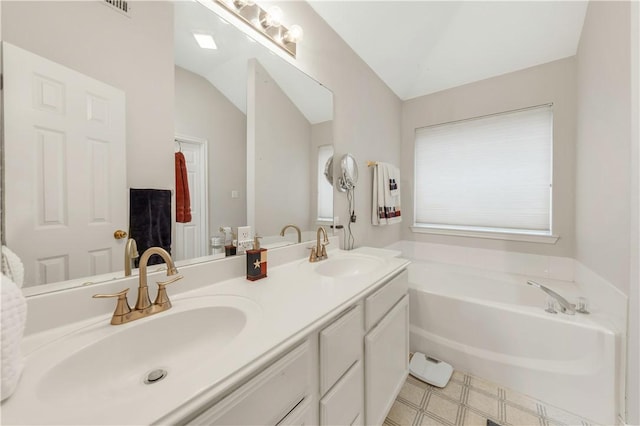 bathroom featuring lofted ceiling, vanity, and a washtub