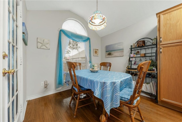 dining area featuring vaulted ceiling and hardwood / wood-style floors