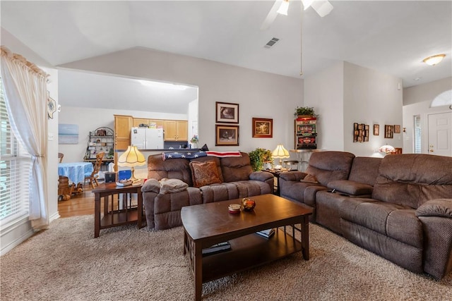 living room with lofted ceiling, light carpet, and ceiling fan