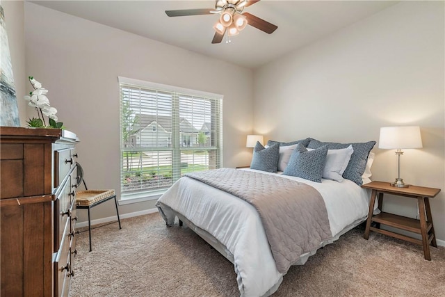 bedroom with baseboards, ceiling fan, and light colored carpet