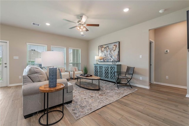 living area with light wood-type flooring, baseboards, visible vents, and recessed lighting