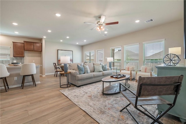 living room featuring ceiling fan, light wood-style flooring, recessed lighting, visible vents, and baseboards