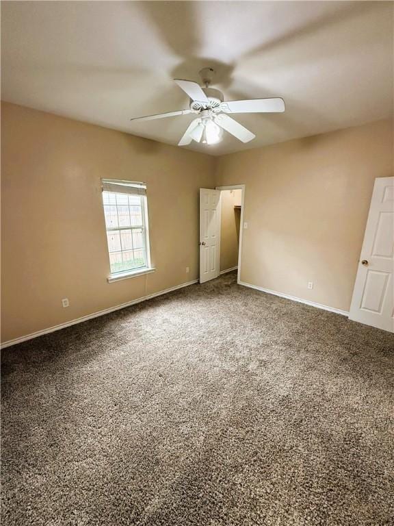 spare room with a ceiling fan, carpet, and baseboards