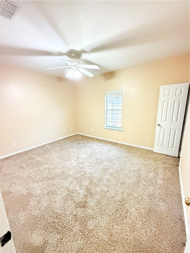 unfurnished room with baseboards, carpet, visible vents, and a ceiling fan