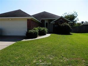 single story home featuring driveway, a front yard, and a garage