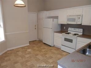kitchen featuring white appliances, a sink, and white cabinetry