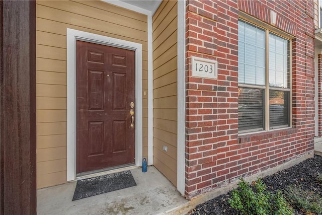 property entrance featuring brick siding