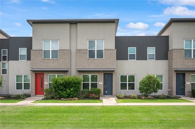 440 William D Fitch Pkwy, College Station, TX 77845 - view of front of home featuring stucco siding, a front yard, and brick siding