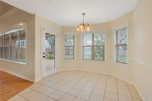 unfurnished dining area with a notable chandelier and light tile patterned floors