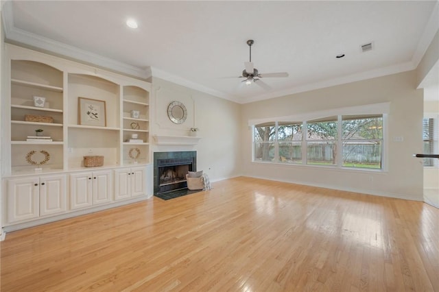 unfurnished living room with a tile fireplace, ceiling fan, and crown molding