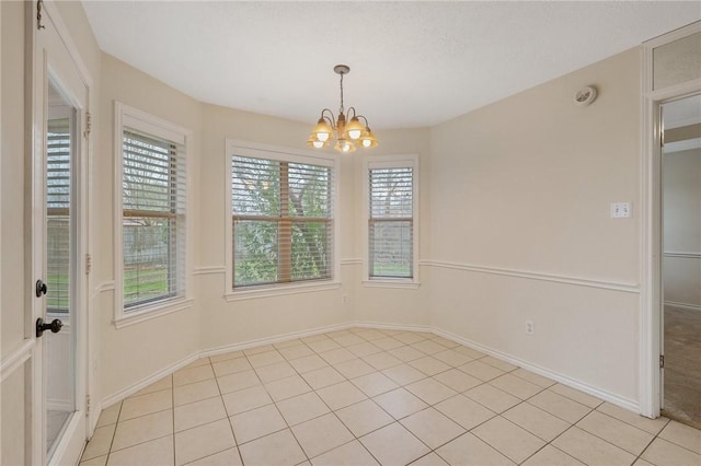 unfurnished dining area featuring light tile patterned floors and an inviting chandelier