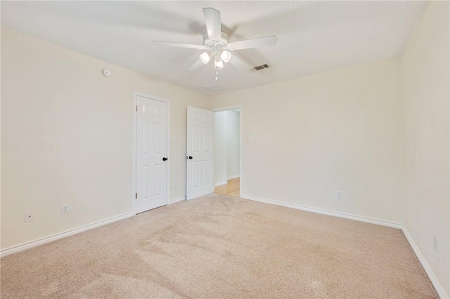 carpeted spare room with ceiling fan