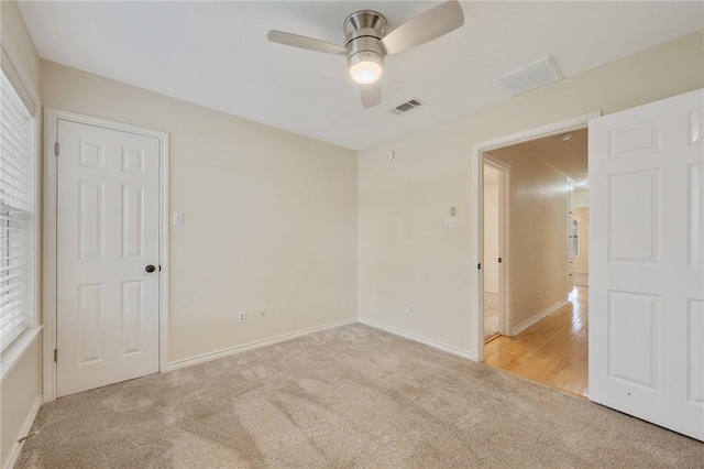 carpeted spare room featuring ceiling fan