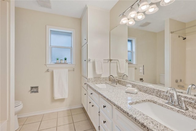 bathroom with tile patterned floors, vanity, toilet, and a wealth of natural light