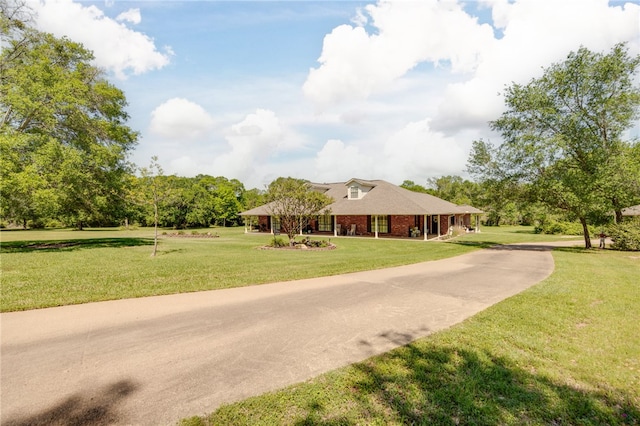 view of front of property with concrete driveway, brick siding, and a front yard