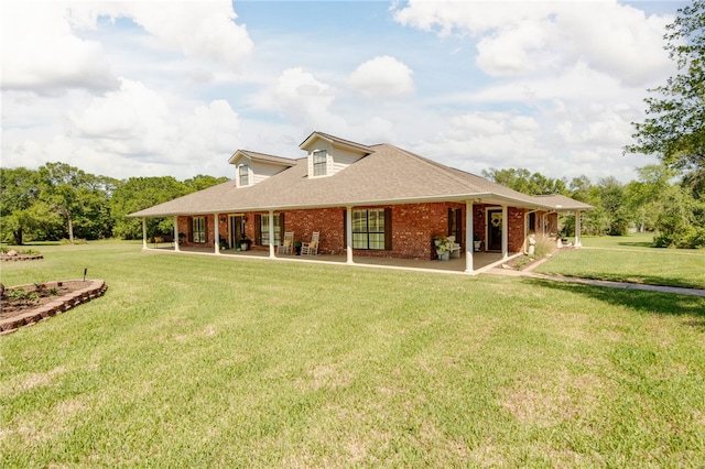 back of property featuring brick siding, a shingled roof, and a yard