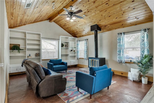 living room with vaulted ceiling with beams, plenty of natural light, ceiling fan, and a wood stove