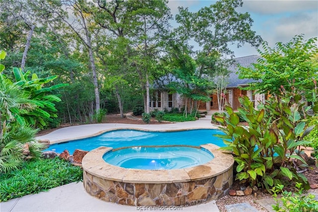 view of pool with an in ground hot tub