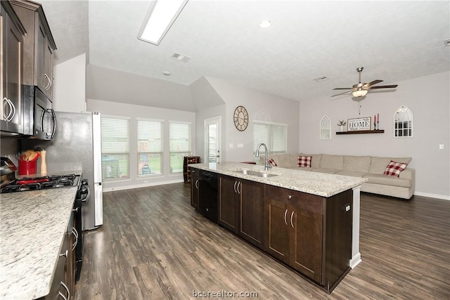 kitchen featuring dark wood-type flooring, black appliances, sink, ceiling fan, and light stone countertops