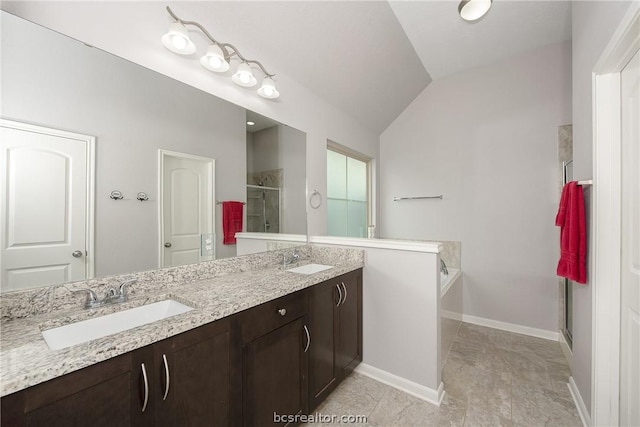 bathroom with vanity, vaulted ceiling, and independent shower and bath