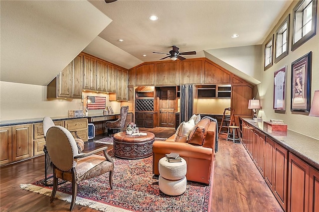 interior space with vaulted ceiling, ceiling fan, and dark wood-type flooring