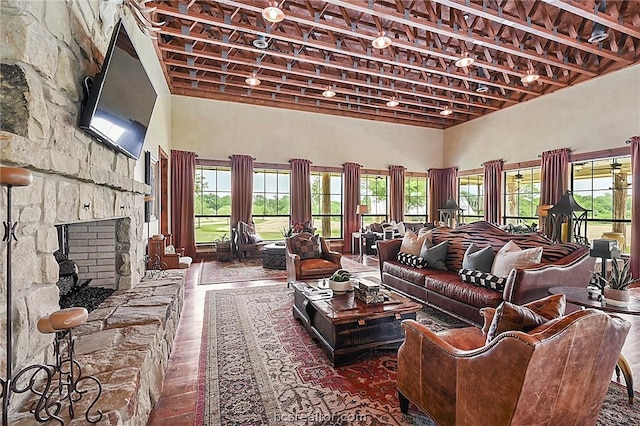 living room with a fireplace, a towering ceiling, and hardwood / wood-style flooring