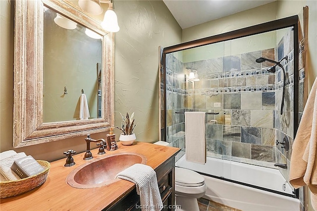 full bathroom featuring vanity, bath / shower combo with glass door, and toilet