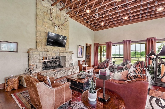 living room with hardwood / wood-style flooring, a fireplace, and high vaulted ceiling