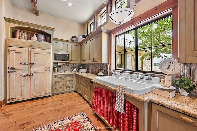 kitchen featuring decorative backsplash, light stone countertops, sink, beam ceiling, and light hardwood / wood-style floors