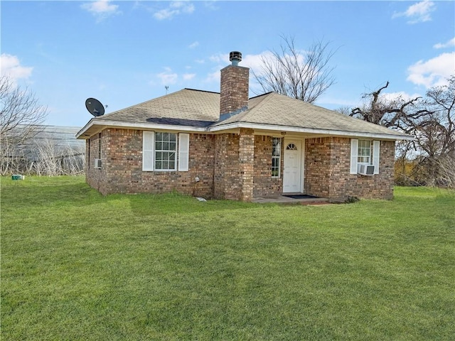 back of property featuring brick siding, a lawn, a chimney, and cooling unit