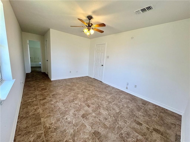 spare room featuring a ceiling fan, visible vents, and baseboards