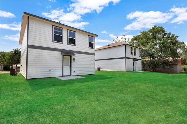 back of property with central AC and a yard