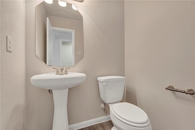 bathroom with hardwood / wood-style floors and toilet