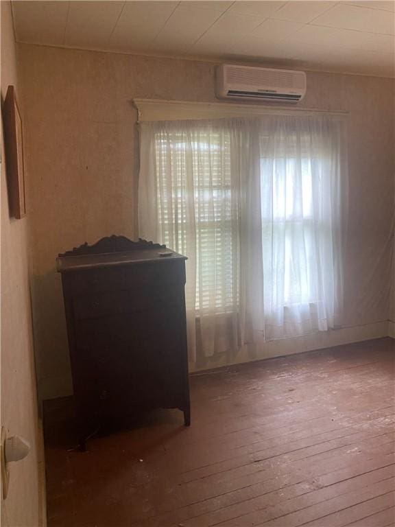 5225 Colorado St, Richards, TX 77873 - empty room with a wall unit AC and hardwood / wood-style flooring