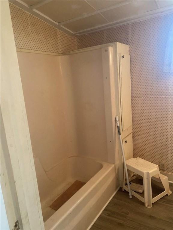 5225 Colorado St, Richards, TX 77873 - bathroom with wallpapered walls, wood finished floors, and bathing tub / shower combination
