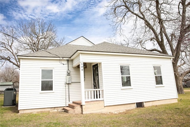 400 N Brazos St, Burton, TX 77835 - view of front of property featuring a shingled roof, a front yard, and central AC