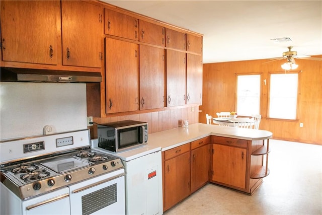 400 N Brazos St, Burton, TX 77835 - kitchen featuring stainless steel microwave, a peninsula, under cabinet range hood, range with two ovens, and light countertops