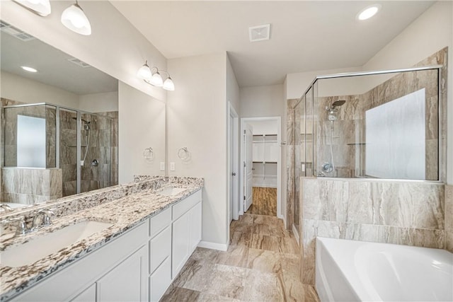 bathroom featuring vanity and independent shower and bath