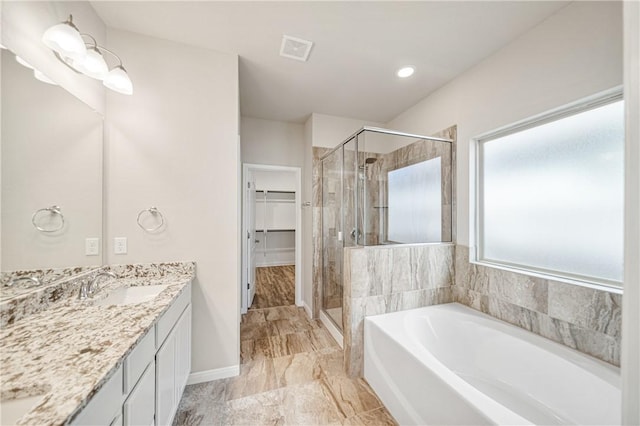 bathroom featuring vanity and independent shower and bath