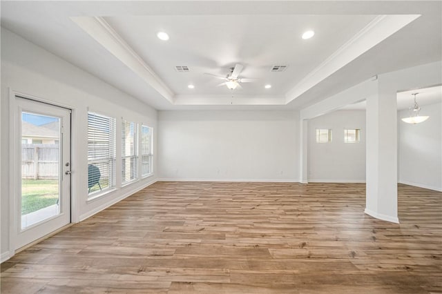 spare room featuring light hardwood / wood-style floors, a raised ceiling, ceiling fan, and ornamental molding