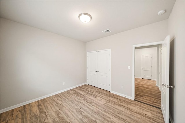 unfurnished bedroom featuring light wood-type flooring and a closet