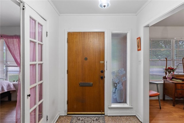 entrance foyer featuring crown molding and baseboards