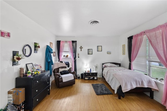 bedroom featuring light wood-style floors and visible vents