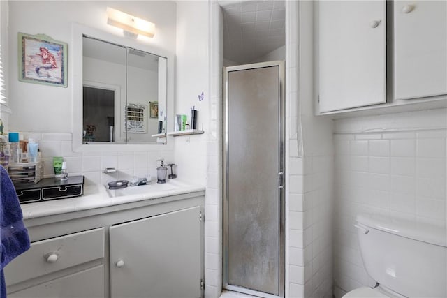 bathroom featuring vanity, backsplash, a stall shower, and toilet