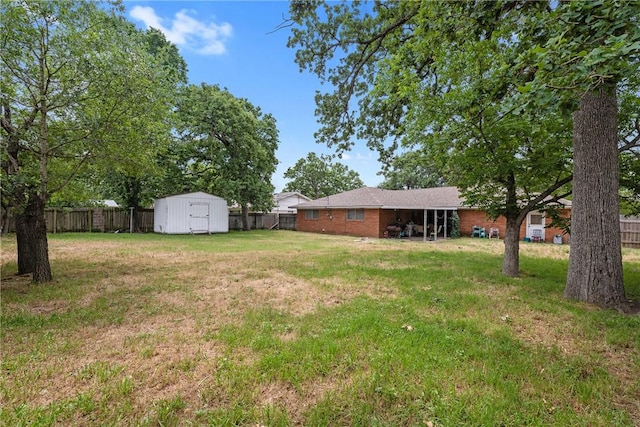 view of yard featuring a fenced backyard, a storage unit, and an outbuilding
